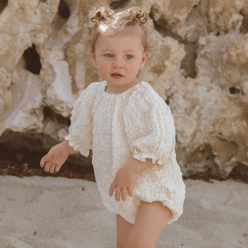 Romper for baby girls with vintage puff sleeves and breathable cream crinkle fabric