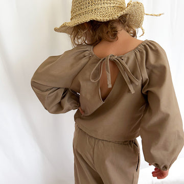 4 year old girl wearing brown linen-cotton puff sleeve top and relaxed elastic-waist pants