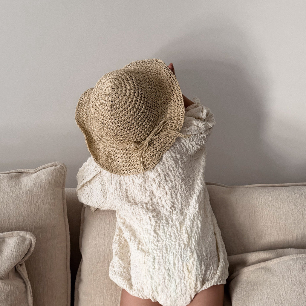 Children’s straw hat styled for outdoor play, with soft natural fibres and classic shape