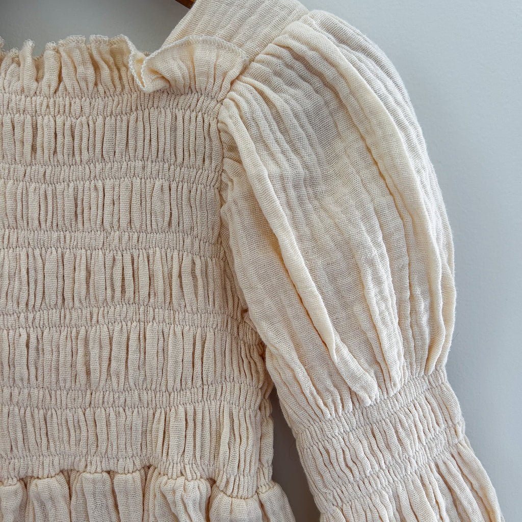 Vintage-inspired baby romper with stretchy smocked top and puff sleeves