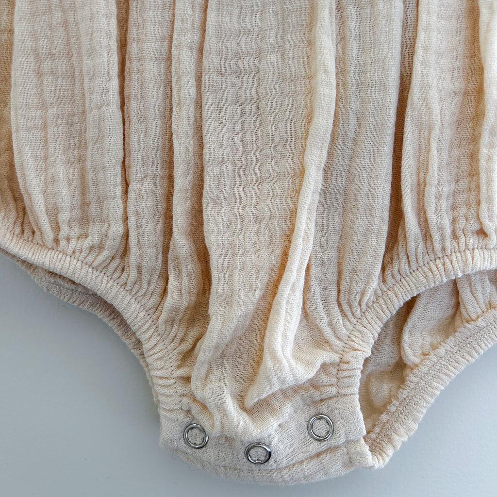 White puff sleeve romper for babies with easy snap diaper closures