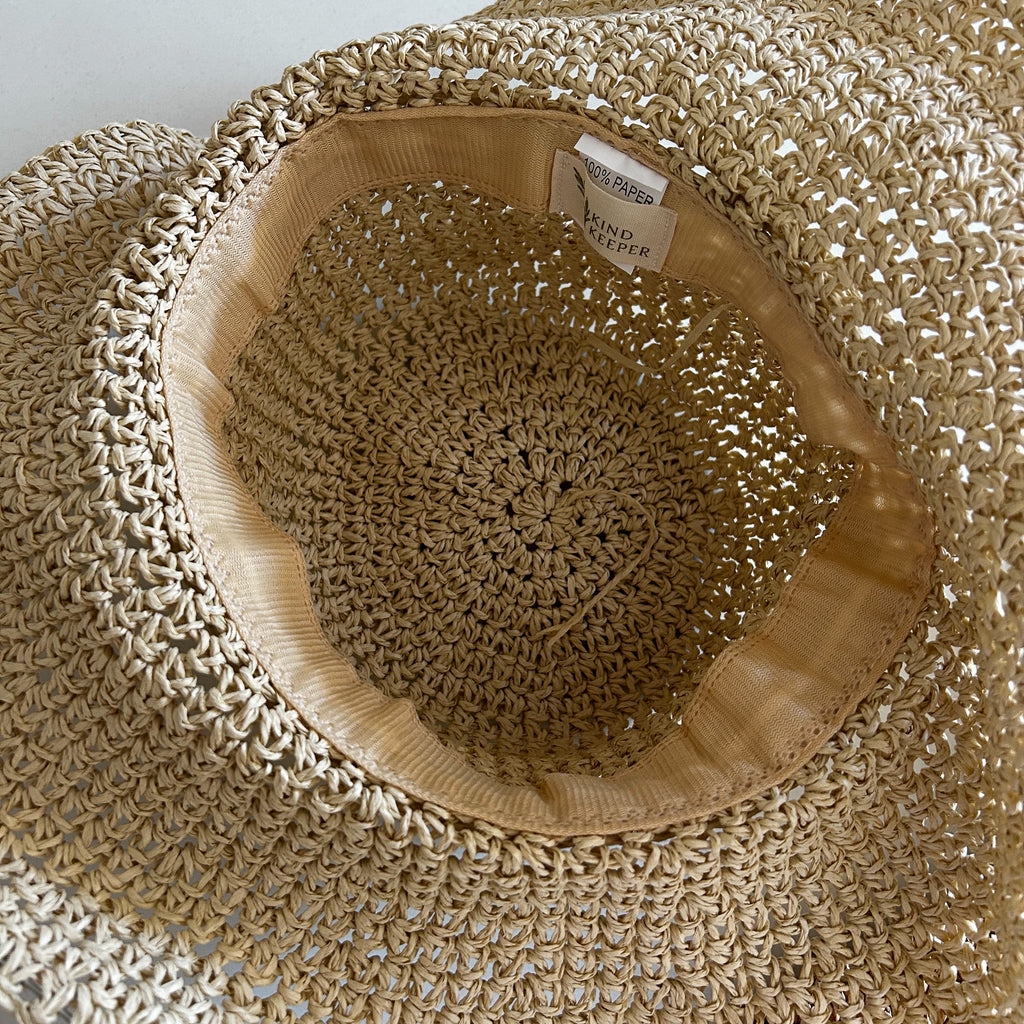 Neutral adult straw hat with structured brim and 58cm inner band, styled for beach days